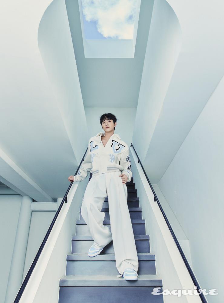 멀티패치 바서티 블루종, 화이트 와이드 팬츠, LV 트레이너 슈즈 모두 루이 비통.